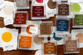 Collection of stamp ink pads with 'Stamp It Colors!' text on a wooden surface.