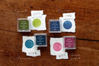 Set of stamp ink pads with colored stamps on a wooden surface